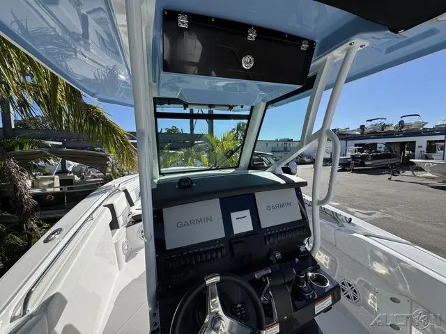 Slide: The Image of 2025 Blackfin 272CC boat cockpit with Garmin navigation system, steering wheel, and outdoor view. - 25