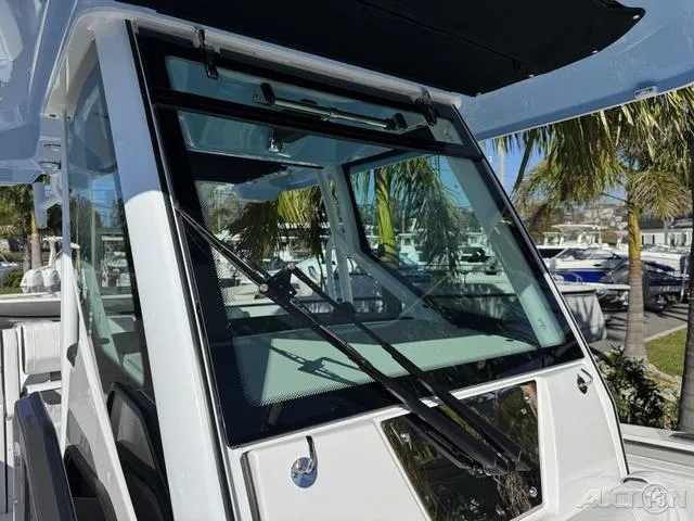 Slide: The Image of 2025 Blackfin 272CC boat windshield with wipers, docked near palm trees. - 33