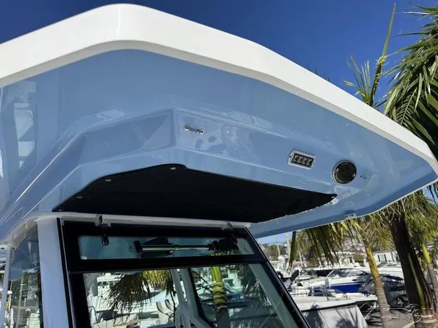 Slide: The Image of 2025 Blackfin 272CC boat canopy with blue finish and marina background. - 34