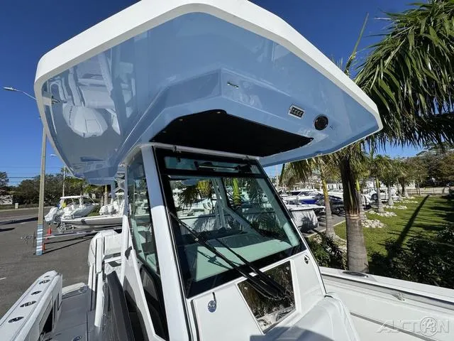 Slide: The Image of 2025 Blackfin 272CC boat with sleek design and modern features, docked near palm trees. - 35