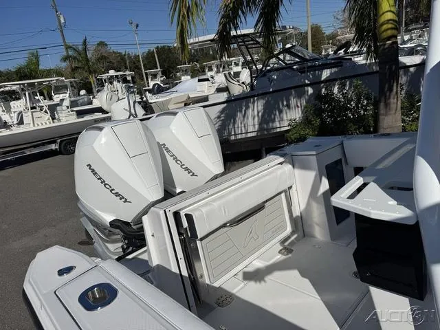 Slide: The Image of 2025 Blackfin 272CC boat with dual Mercury engines, docked under palm trees. - 39