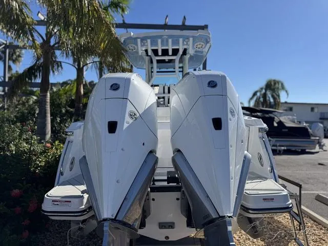 Slide: The Image of 2025 Blackfin 272CC boat with dual outboard engines, docked under clear blue sky. - 5