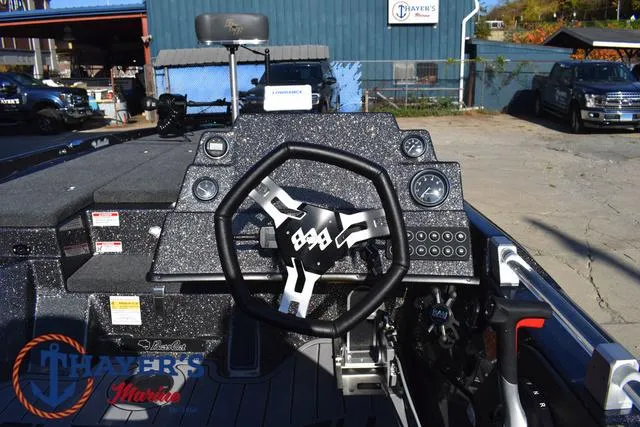 Slide: The Image of 2025 Bass Cat Cougar FTD boat dashboard with steering wheel and controls at Thayer's Marine. - 13