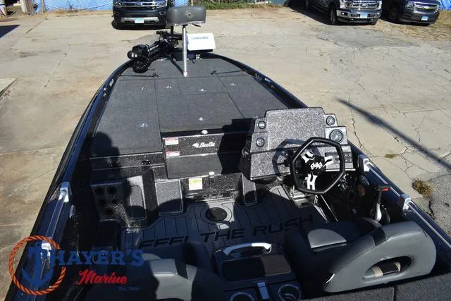 Slide: The Image of 2025 Bass Cat Cougar FTD boat interior with steering wheel and seating, parked outdoors. - 26