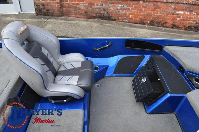 Slide: The Image of 2018 Nitro Z21 boat interior with gray and blue seating, dashboard, and storage compartments. - 22
