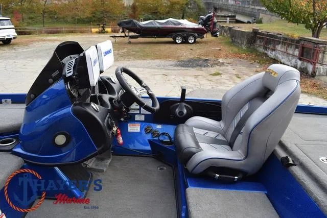 Slide: The Image of 2018 Nitro Z21 boat interior with steering wheel and seat, parked outdoors. - 26