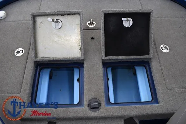 Slide: The Image of 2018 Nitro Z21 boat storage compartments with open lids, gray carpet, and blue interior. - 33
