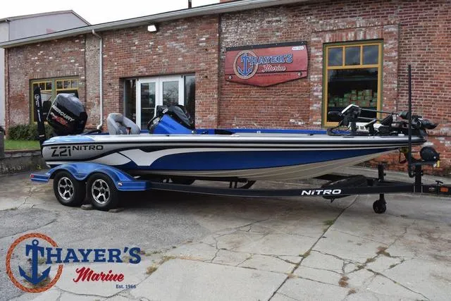 Slide: The Image of 2018 Nitro Z21 boat in blue, parked outside Thayer's Marine brick building. - 44