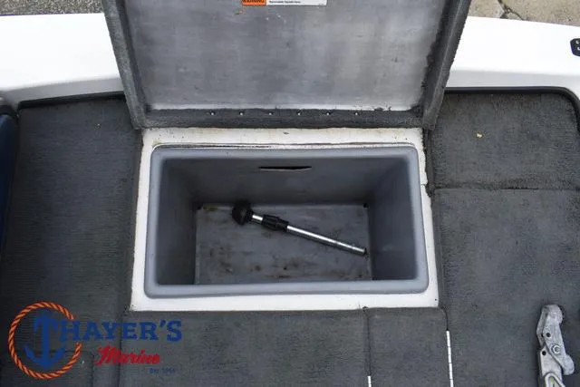 Slide: The Image of Open storage compartment in 2007 Stratos 176XT boat, featuring a tool inside. - 26