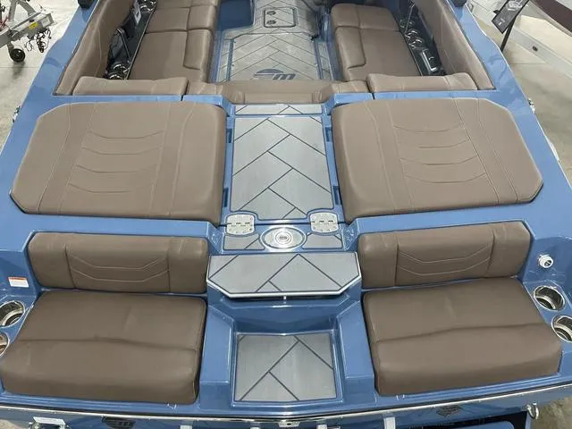 Slide: The Image of 2024 Malibu 23 LSV boat interior with brown seating and blue accents. - 11