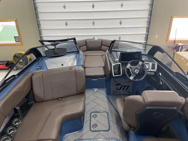 Slide: The Image of 2024 Malibu 23 LSV boat interior with brown seating and modern dashboard. - 13