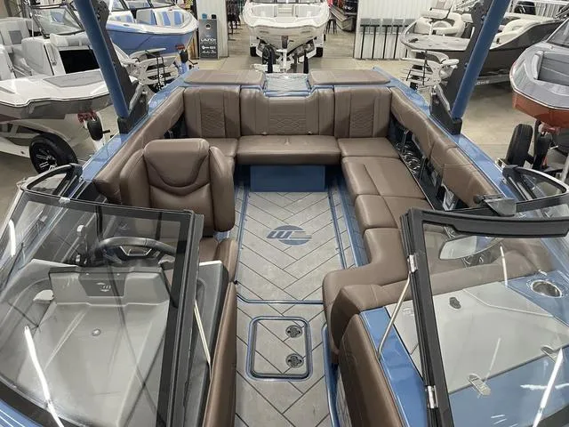 Slide: The Image of 2024 Malibu 23 LSV boat interior with brown seating and blue accents. - 14