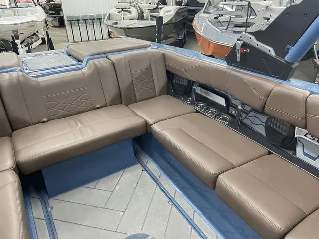 Slide: The Image of 2024 Malibu 23 LSV boat interior with brown leather seating and modern design. - 15