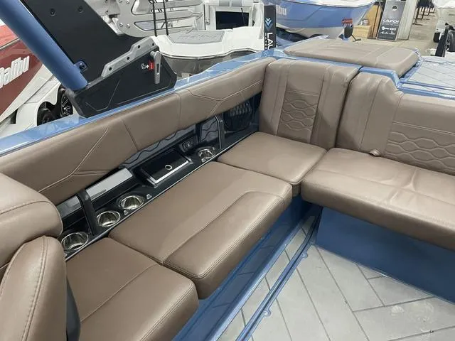 Slide: The Image of 2024 Malibu 23 LSV boat interior with brown leather seating and cup holders. - 16