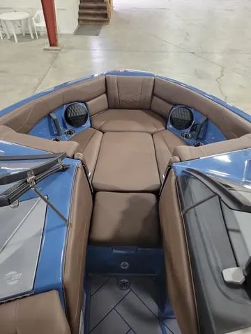 Slide: The Image of 2024 Malibu 23 LSV boat interior with brown seating and blue accents. - 4