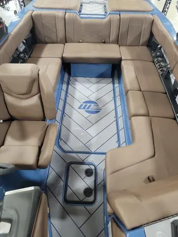 Slide: The Image of 2024 Malibu 23 LSV boat interior with brown seating and blue accents. - 5