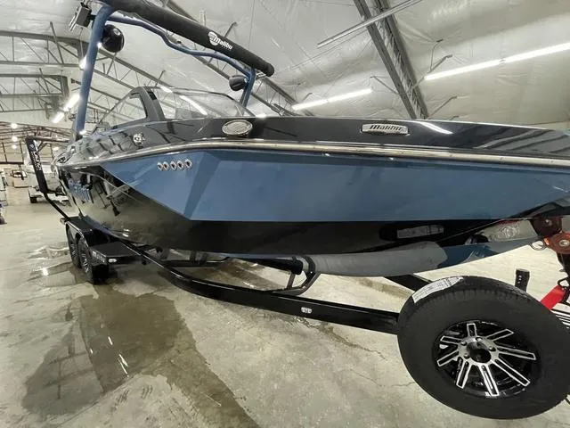 Slide: The Image of 2024 Malibu 23 LSV boat in a showroom, featuring sleek blue and black design. - 7