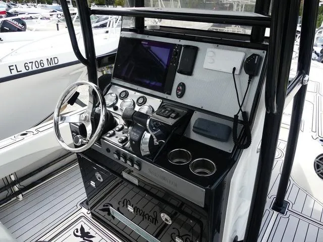 Slide: The Image of 2018 ShearWater 270 Carolina Flare boat console with steering wheel and navigation equipment. - 10