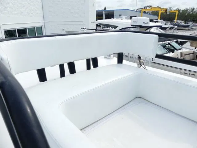 Slide: The Image of 2018 ShearWater 270 Carolina Flare boat seating area, white upholstery, marina background. - 23