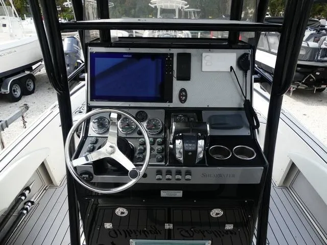 Slide: The Image of 2018 ShearWater 270 Carolina Flare boat dashboard with steering wheel and navigation controls. - 8