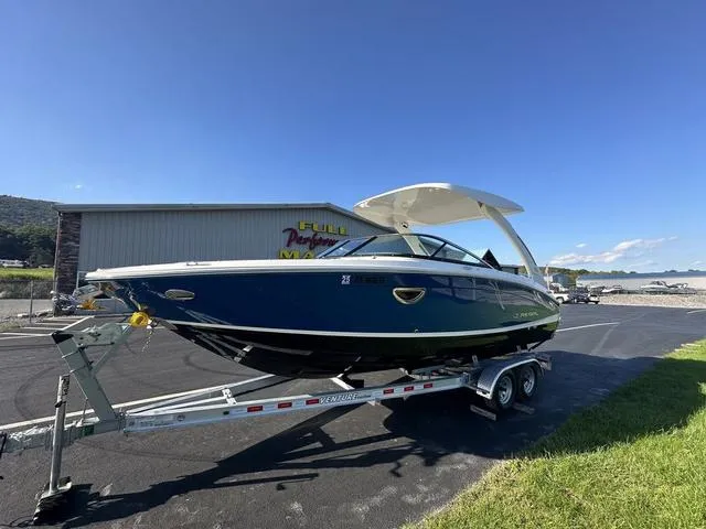 Slide: The Image of 2023 Regal LS6 boat on trailer, parked outdoors under clear blue sky. - 2