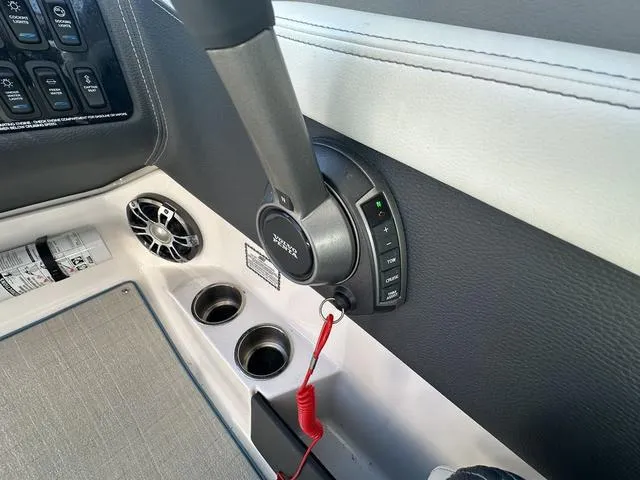 Slide: The Image of 2023 Regal LS6 boat interior with control panel, throttle, and cup holders. - 20