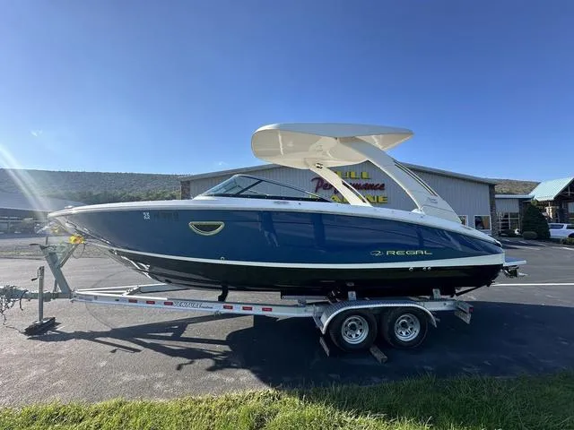 Slide: The Image of 2023 Regal LS6 boat on trailer under clear blue sky. - 3