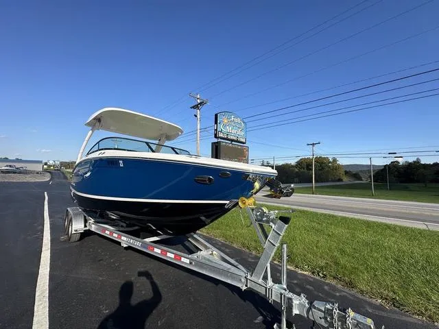 Slide: The Image of 2023 Regal LS6 boat on trailer, parked near a road under clear blue sky. - 6