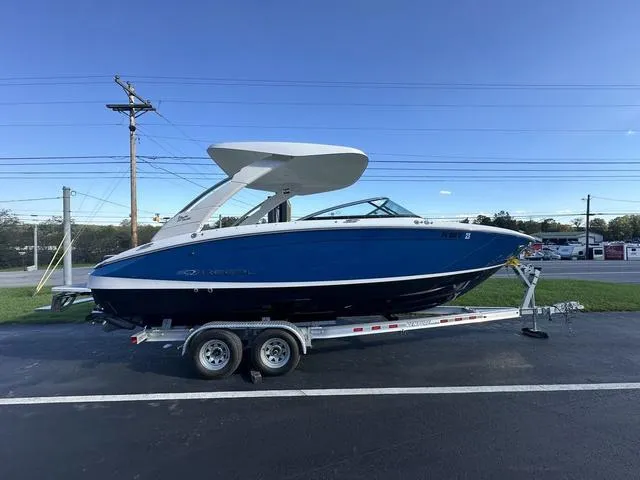 Slide: The Image of 2023 Regal LS6 boat on trailer, blue hull, parked outdoors. - 7