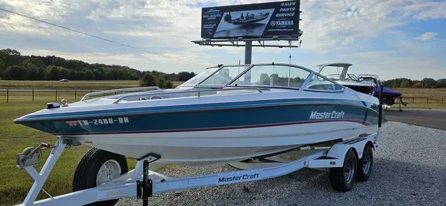 Slide: The Image of 1993 MasterCraft Maristar 225 boat on trailer, parked outdoors under a clear sky. - 3