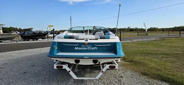 Slide: The Image of 1993 MasterCraft Maristar 225 boat parked on gravel near grassy area. - 5