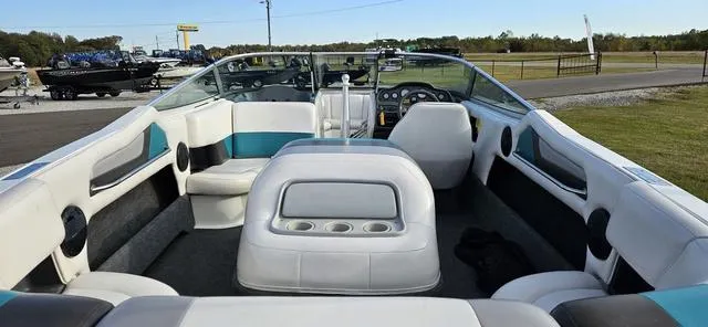 Slide: The Image of 1993 MasterCraft Maristar 225 boat interior with white and teal seating, cup holders, and dashboard. - 8