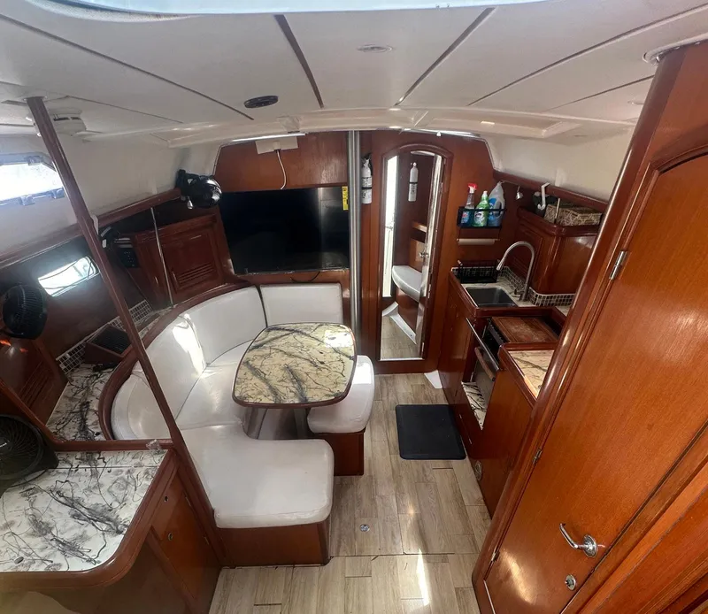 Slide: The Image of Interior of 2006 Beneteau 393 yacht with dining area and kitchen. - 13
