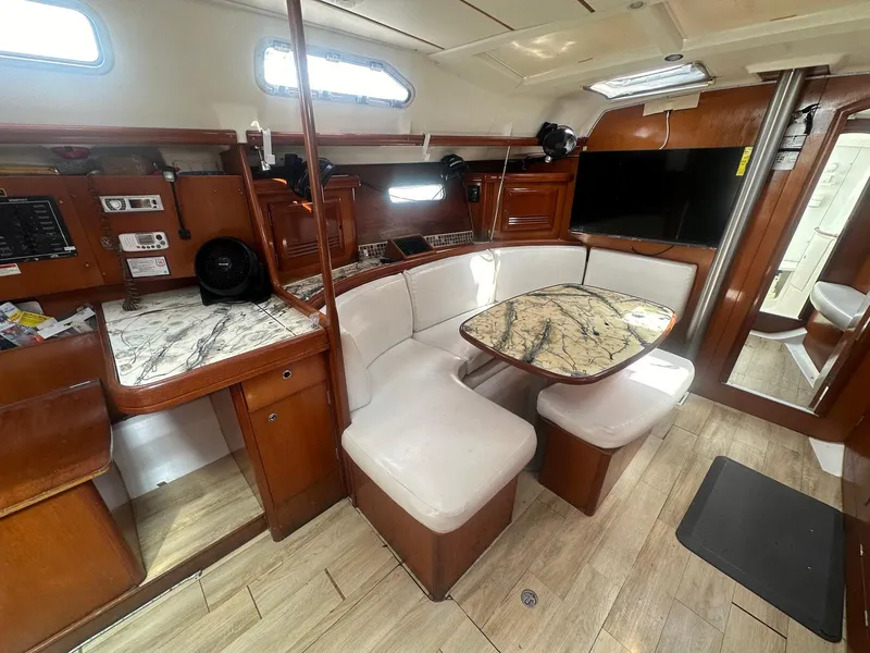 Slide: The Image of Interior of 2006 Beneteau 393 sailboat with wood finish and cozy seating area. - 14
