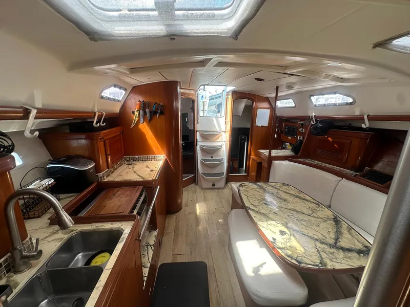 Slide: The Image of Interior of 2006 Beneteau 393 sailboat with kitchen and dining area. - 16