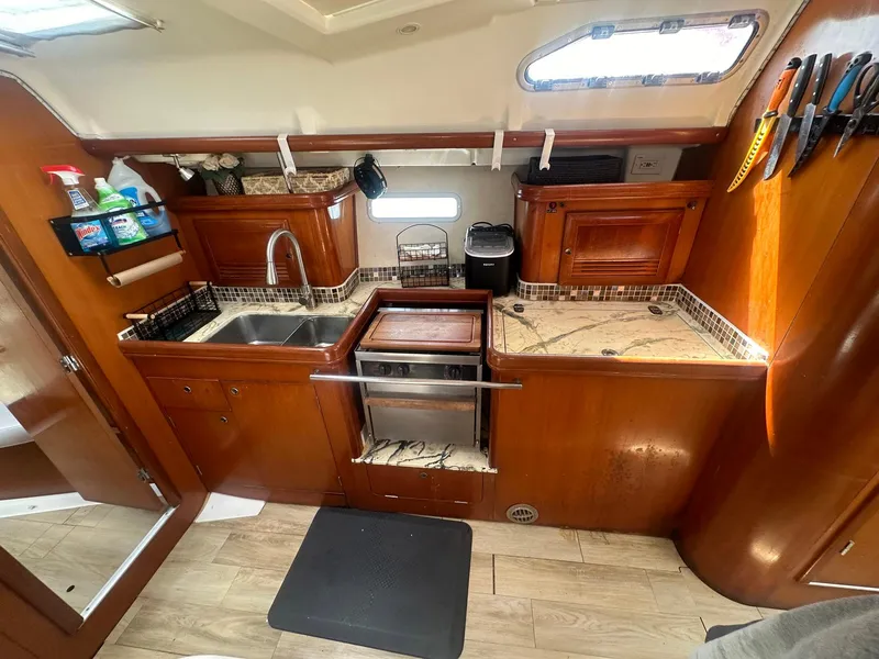 Slide: The Image of Interior of 2006 Beneteau 393 yacht kitchen with wooden cabinetry and modern appliances. - 18
