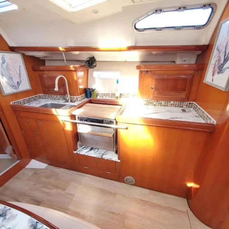 Slide: The Image of Interior of 2006 Beneteau 393 yacht kitchen with wood cabinetry and modern appliances. - 20
