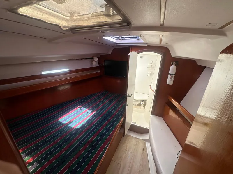 Slide: The Image of Interior cabin of 2006 Beneteau 393 yacht with bed, skylight, and wooden finish. - 24