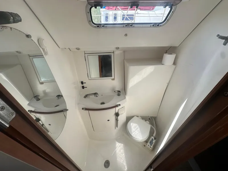 Slide: The Image of Beneteau 393 2006 yacht bathroom with sink, toilet, and mirror. - 26