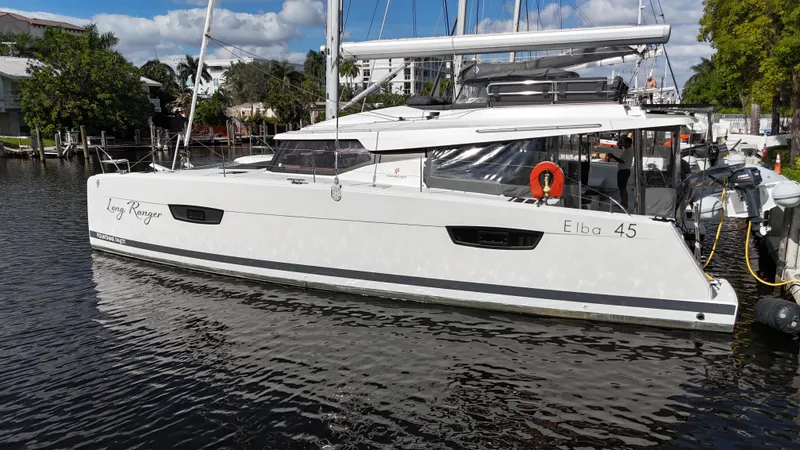 Slide: The Image of 2020 Fountaine Pajot Elba 45 catamaran docked in a marina under a sunny sky. - 4