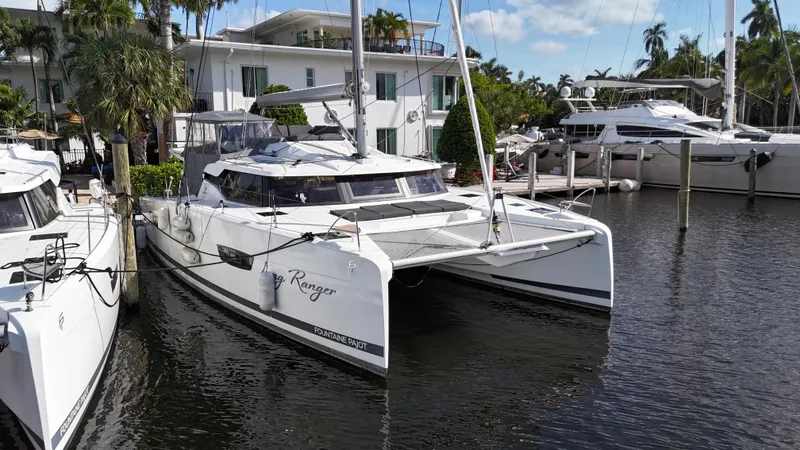 Slide: The Image of 2020 Fountaine Pajot Elba 45 catamaran docked in a marina, surrounded by palm trees. - 7