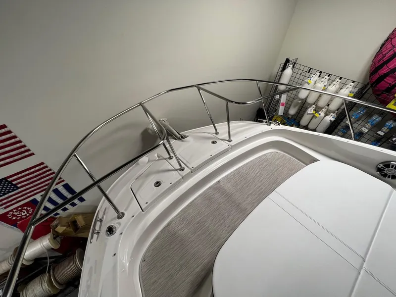 Slide: The Image of 2025 Sea Ray Sundancer 320 Coupe bow with sleek railing and American flags in storage. - 14