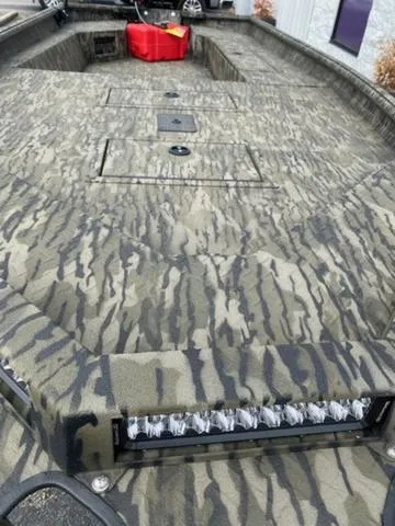 Slide: The Image of 2025 SeaArk 1960 Slayer Pro boat with camouflage pattern and outboard motor. - 3