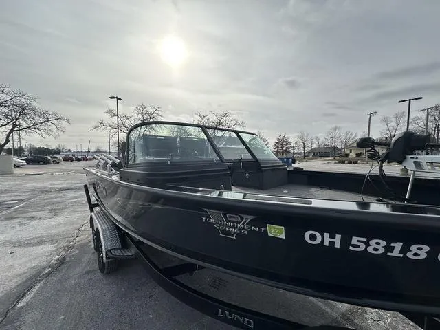 Slide: The Image of 2024 Lund 2175 Pro-V Sport boat in parking lot under cloudy sky. - 18