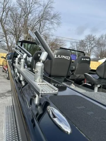 Slide: The Image of 2024 Lund 2175 Pro-V Sport boat, rear view with dual motors, parked on gravel. - 6