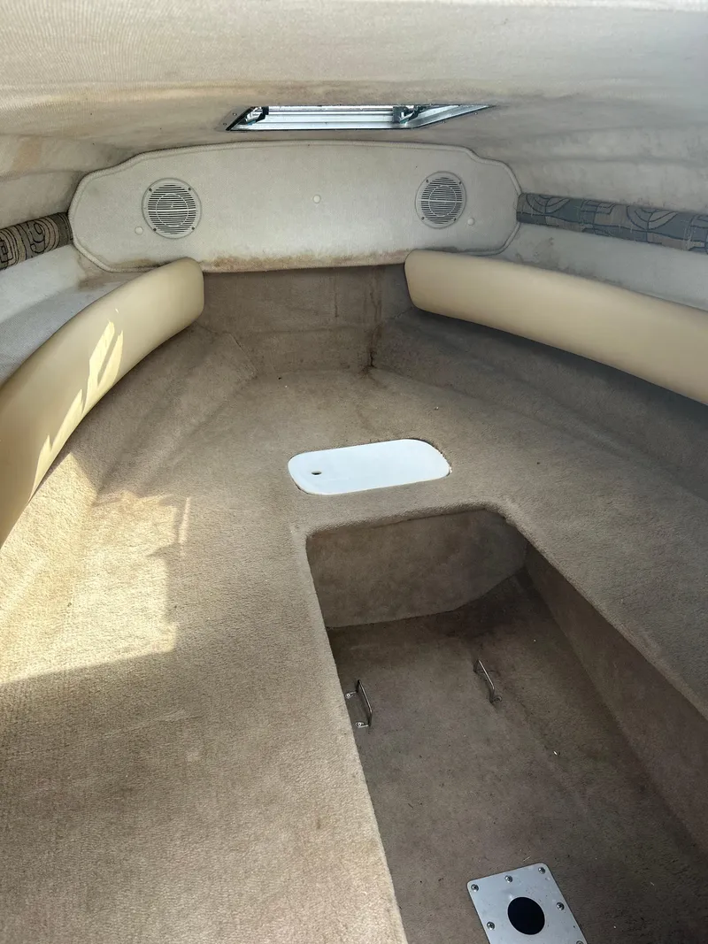 Slide: The Image of Interior of 2002 Chaparral 205SSE Cuddy boat, featuring beige upholstery and compact cabin space. - 8
