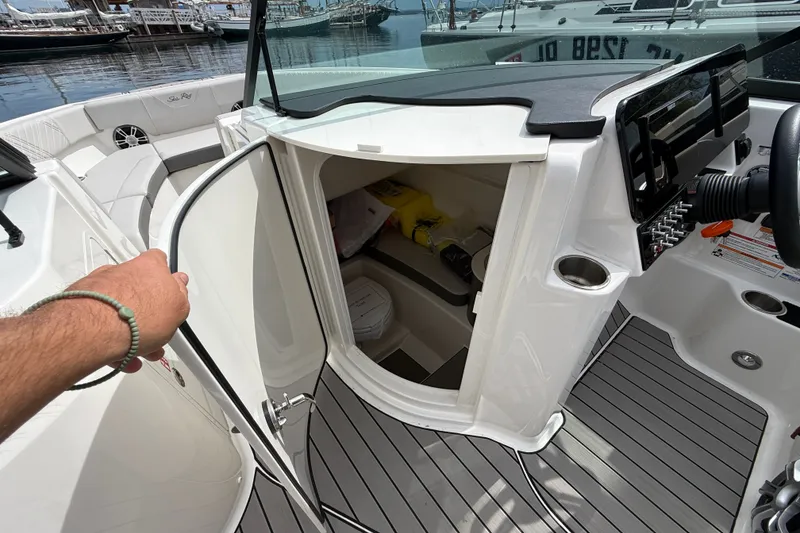 Slide: The Image of 2025 Sea Ray SDX 250 Surf boat interior with open storage compartment and sleek design. - 15