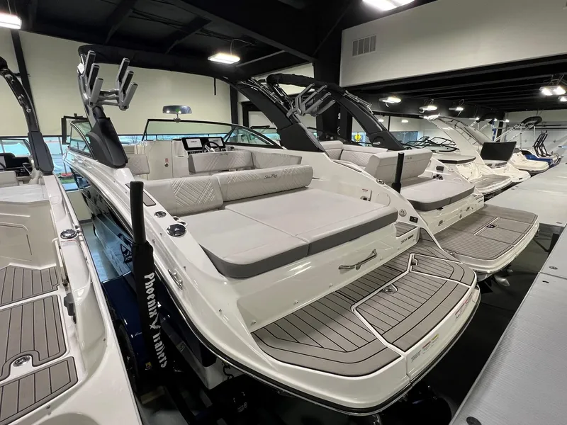 Slide: The Image of 2025 Sea Ray SDX 250 Surf boat in showroom, featuring sleek design and spacious seating. - 3