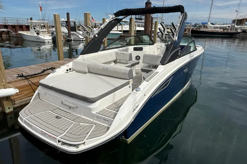 Slide: The Image of 2025 Sea Ray SDX 250 Surf boat docked at marina, featuring sleek design and spacious seating. - 2