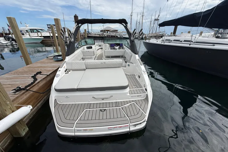 Slide: The Image of 2025 Sea Ray SDX 250 Surf boat docked at marina, showcasing spacious deck and seating. - 1